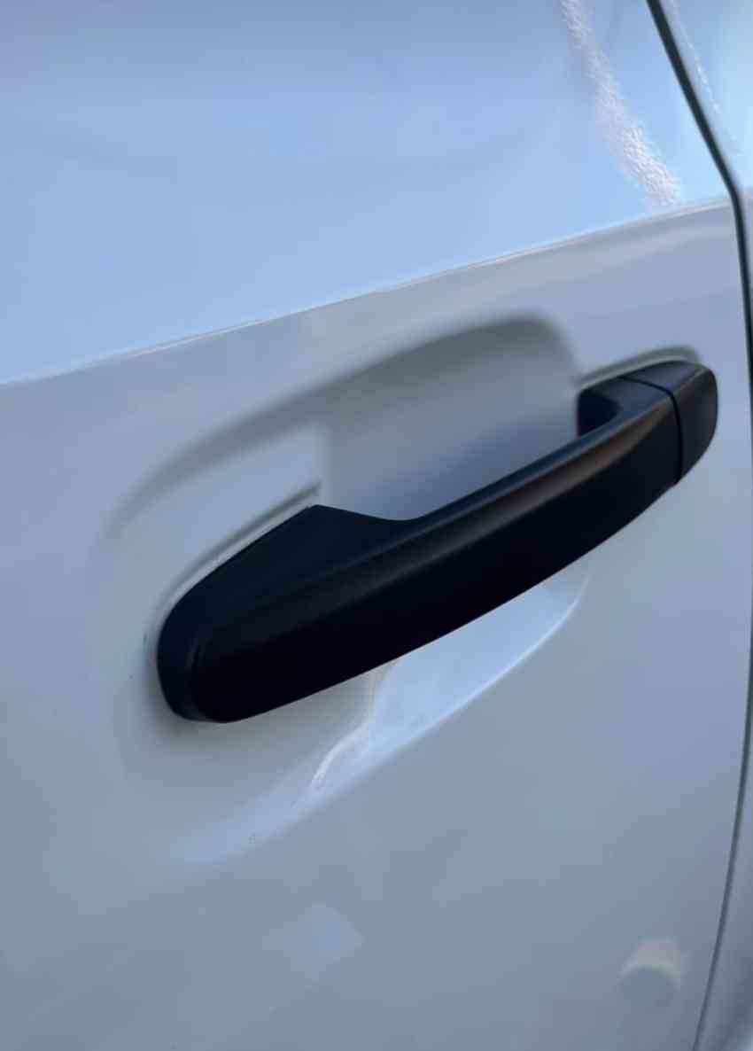 Close-up of a vehicle door handle with premium paint correction and sealant treatment.
