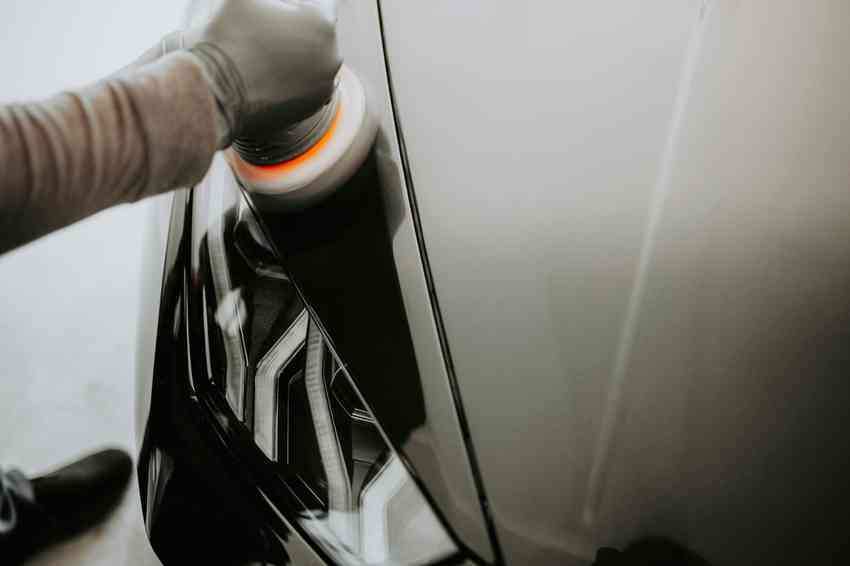 Car undergoing premium paint correction with a polishing tool.